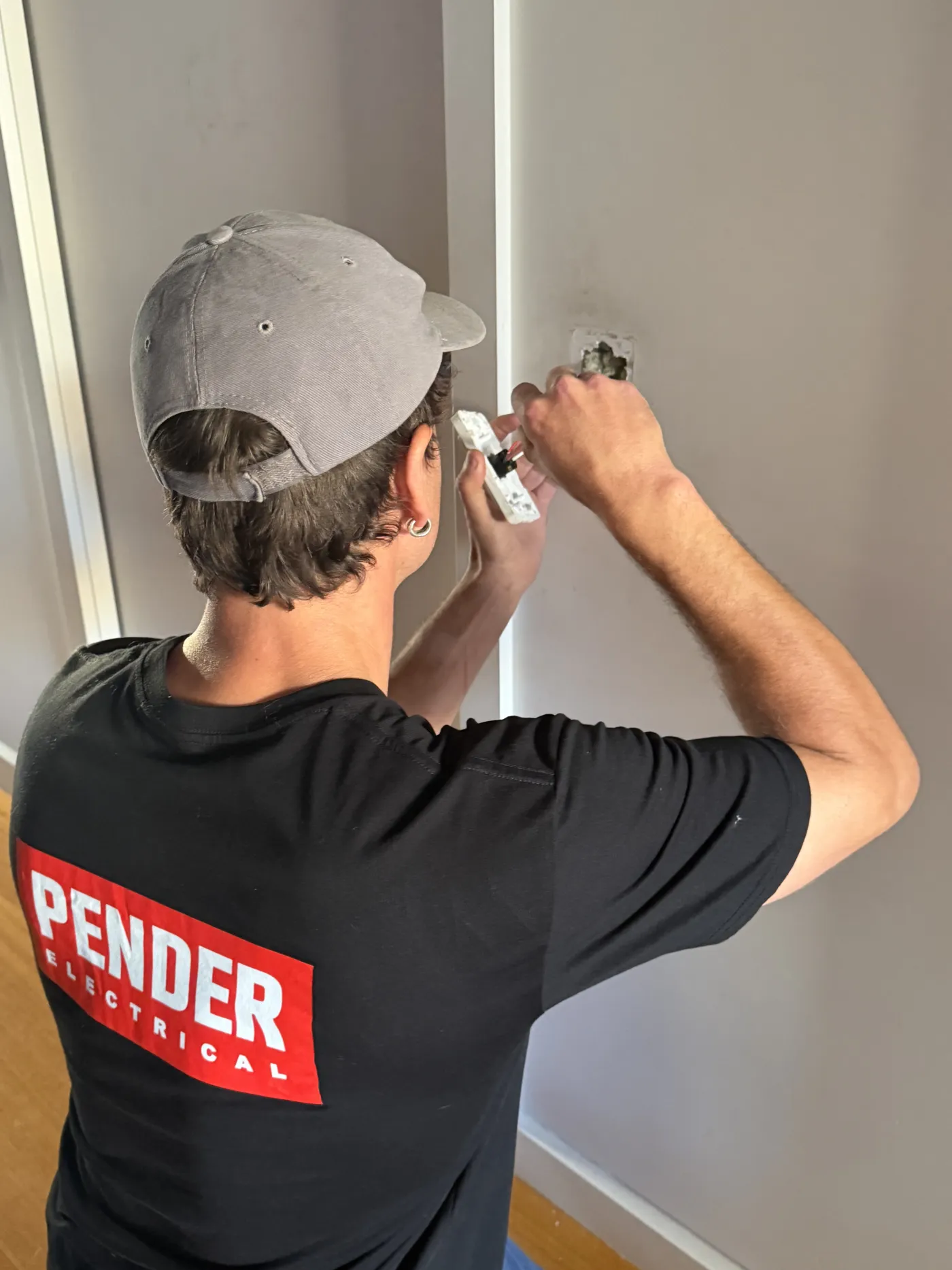 Jack from Pender Electrical fitting a power point on a job in Melbourne's inner north